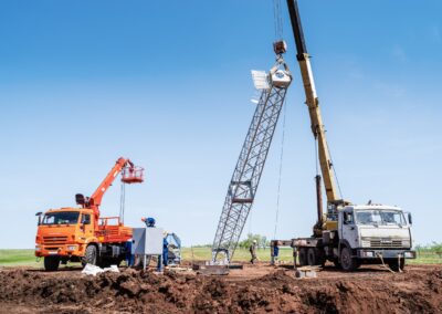 workers using construction equipment install a wind turbine tower